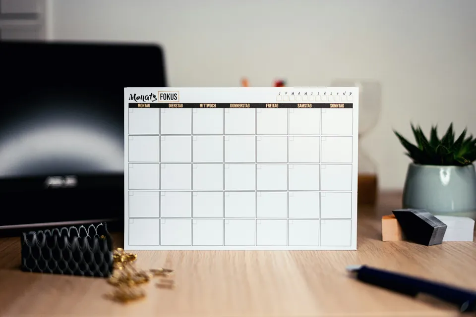 A blank monthly calendar standing on a desk