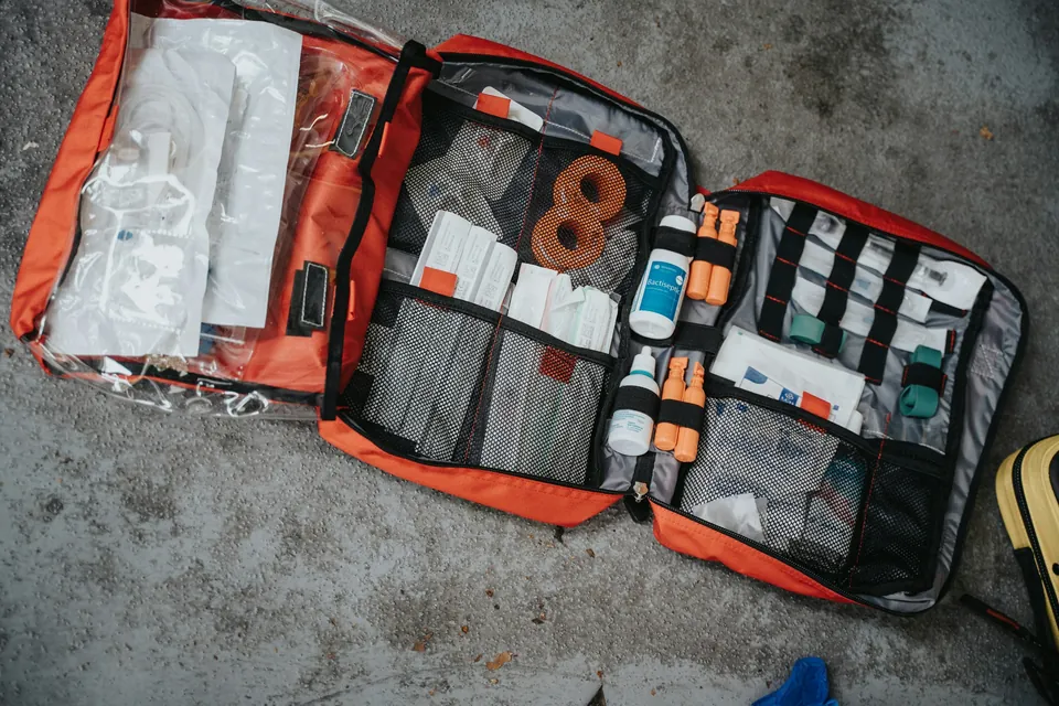 An open emergency first aid bag packed with bandages and supplies