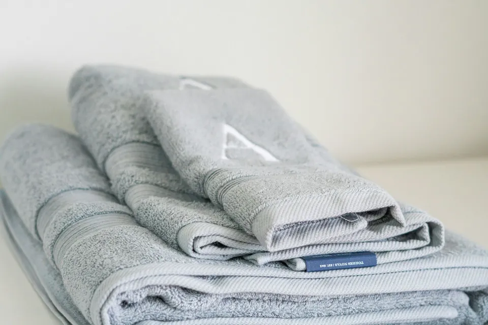 A stack of soft gray folded towels on a table