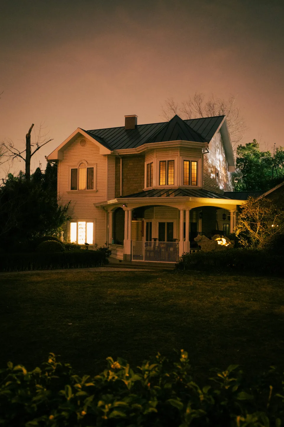 A family home with warm light in the windows at night