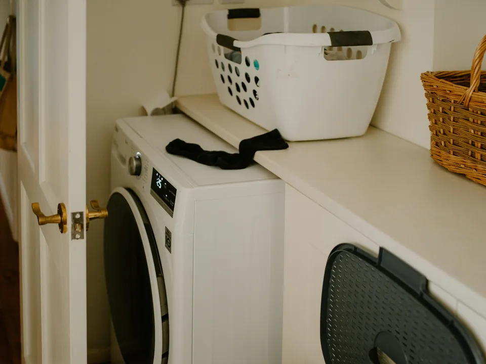 A washing machine with a laundry basket and a single sock