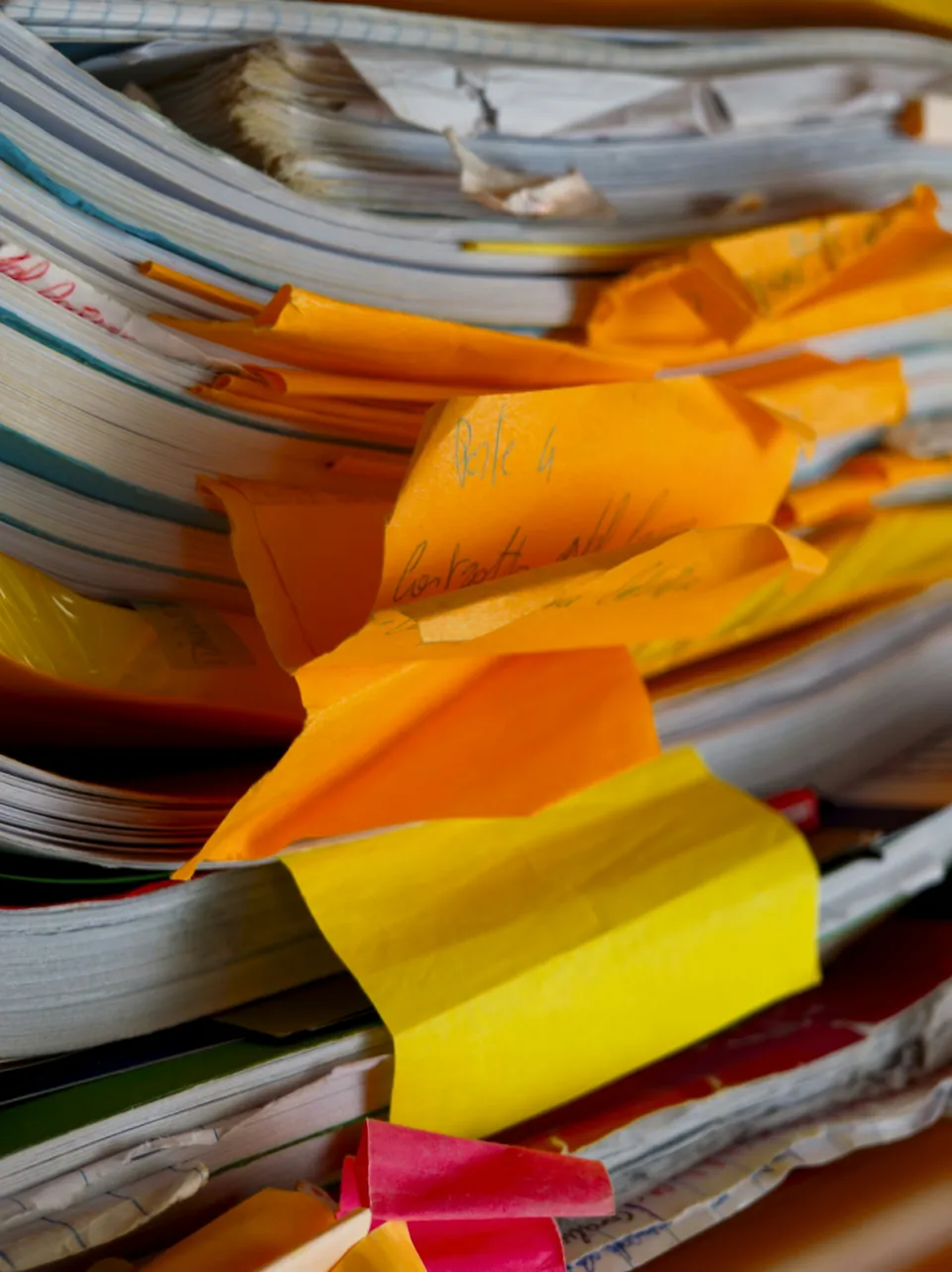 A messy stack of papers and folders