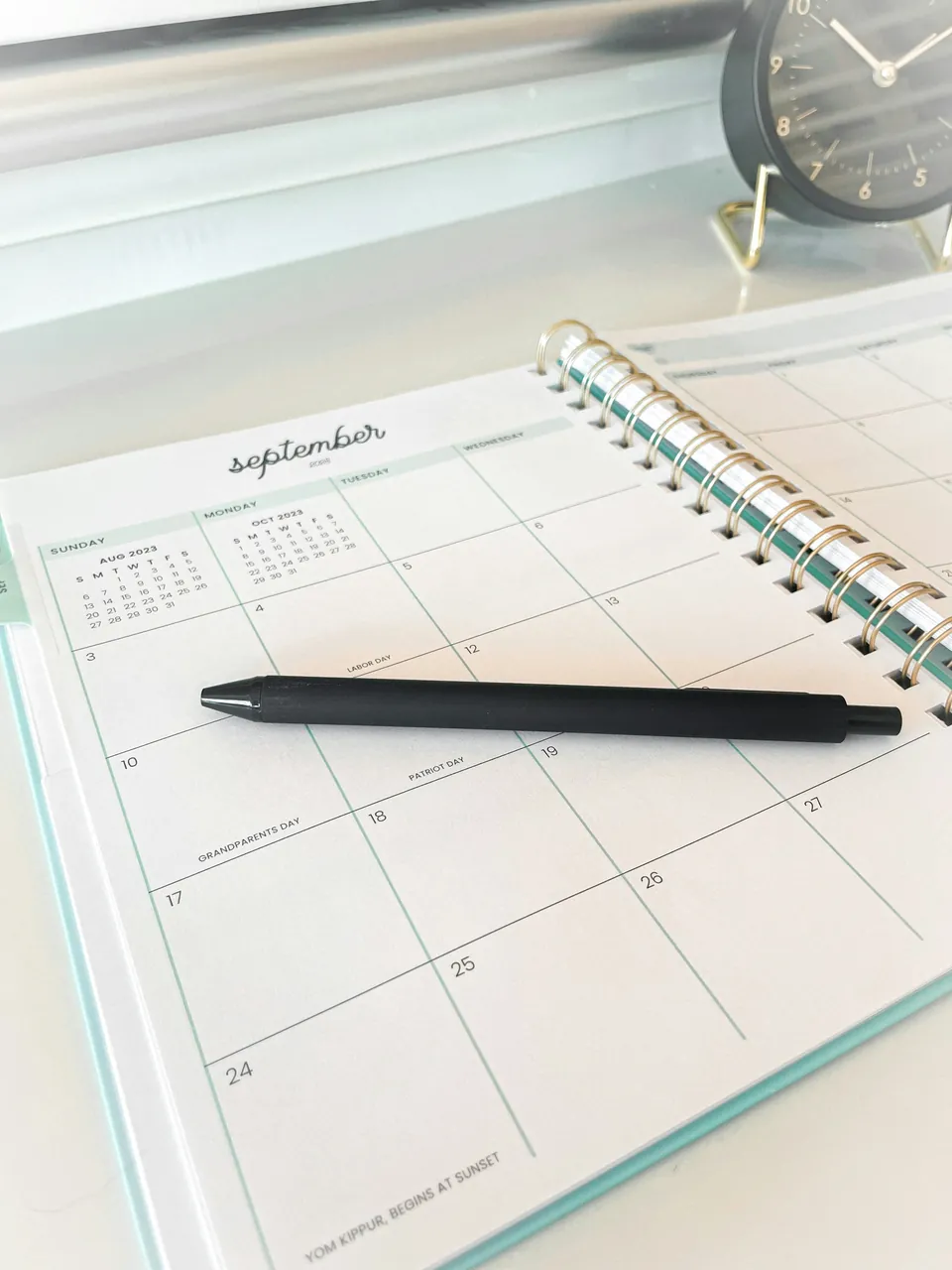 A pen resting on an open monthly planner