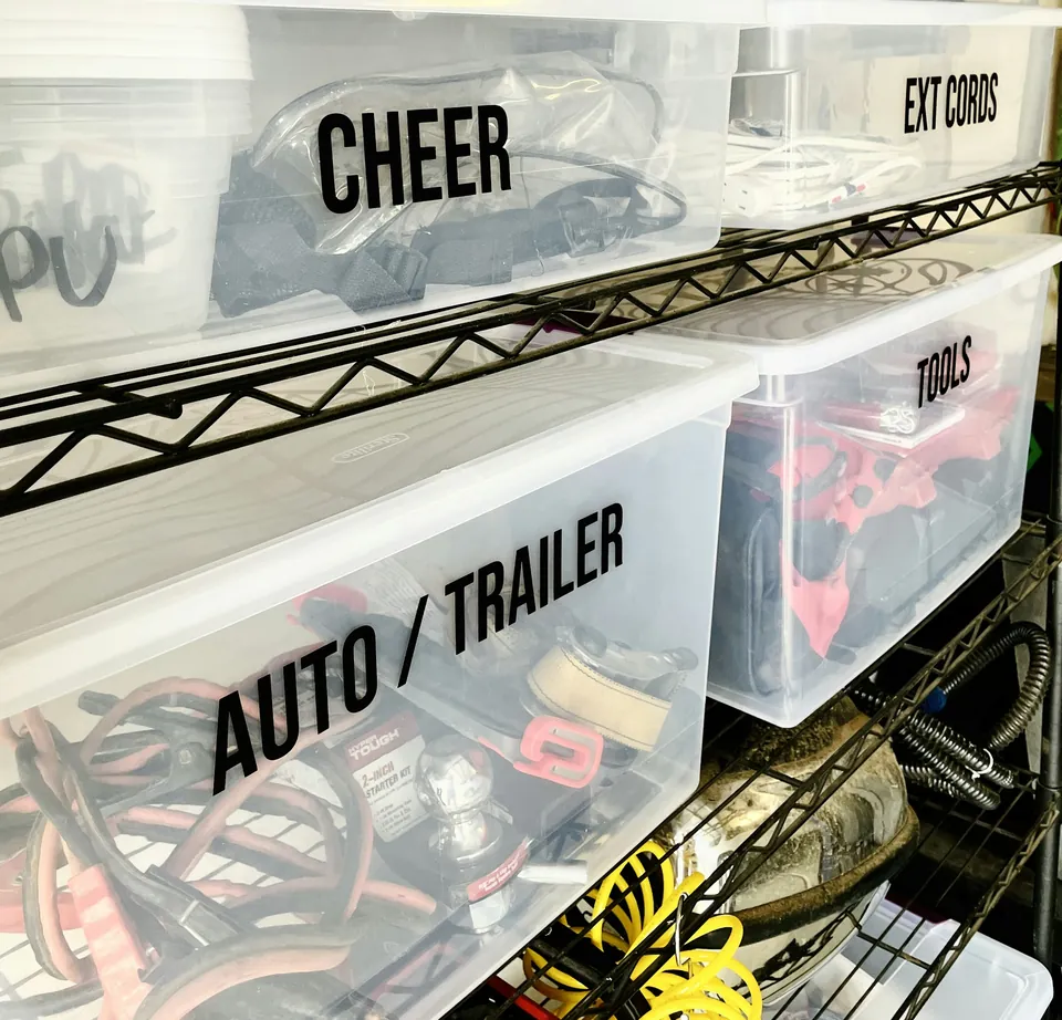 Clear storage bins labeled for cords, tools and car supplies on wire shelving